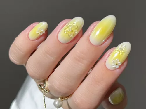 a butter yellow aura manicure with 3D flower accents