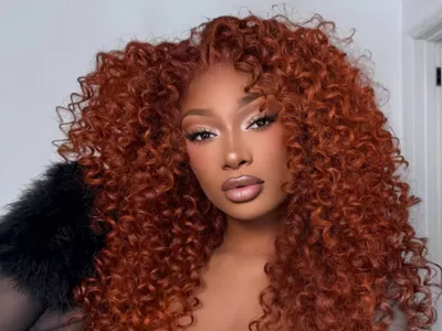 A close up of Megan Thee Stallion with her copper hair in tight curls.